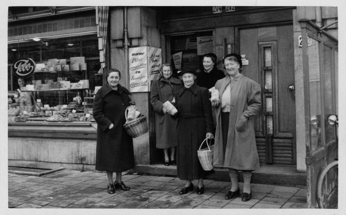 Bepakt met boodschappen verlaten de vrouwen de winkel. Er zijn weer goede zaken gedaan. Bepakt met boodschappen verlaten de vrouwen de winkel. Er zijn weer goede zaken gedaan.