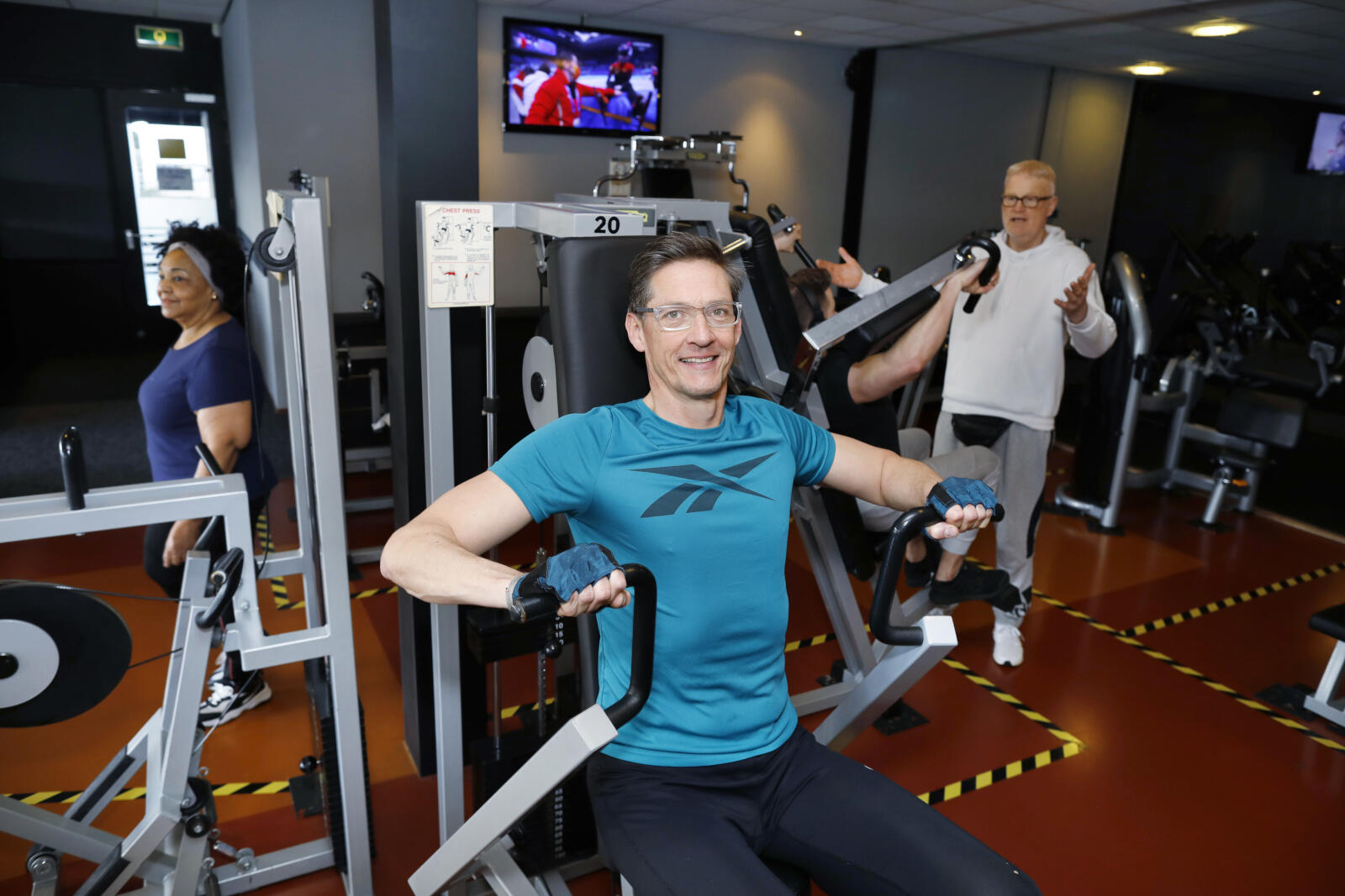 Bij Fitness America van Dick Huisman (witte sweater), ‘een Rotterdamse ondernemer die naast alle COVID-ellende ook met ziekte kreeg te kampen. Hij knokt zich er elke dag weer vrolijk doorheen, en is ook nog eens politiek geïnteresseerd.’ Bij Fitness America van Dick Huisman (witte sweater), ‘een Rotterdamse ondernemer die naast alle COVID-ellende ook met ziekte kreeg te kampen. Hij knokt zich er elke dag weer vrolijk doorheen, en is ook nog eens politiek geïnteresseerd.’